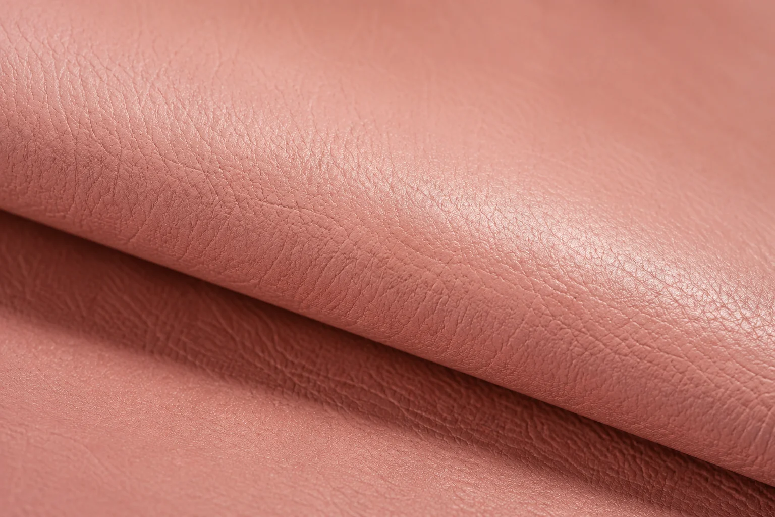 Semi-aniline leather in pink colour close-up showing pigment uniformity and protective finish